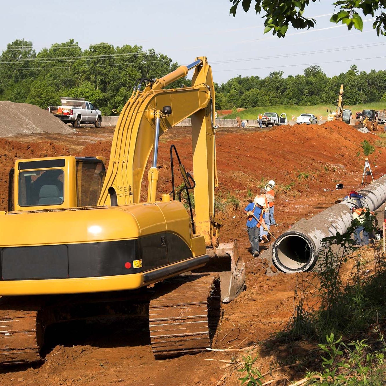 Digging dirt. Trackhoe in ditch helping to lay drainage pipe for new residential neighbor hood and highway