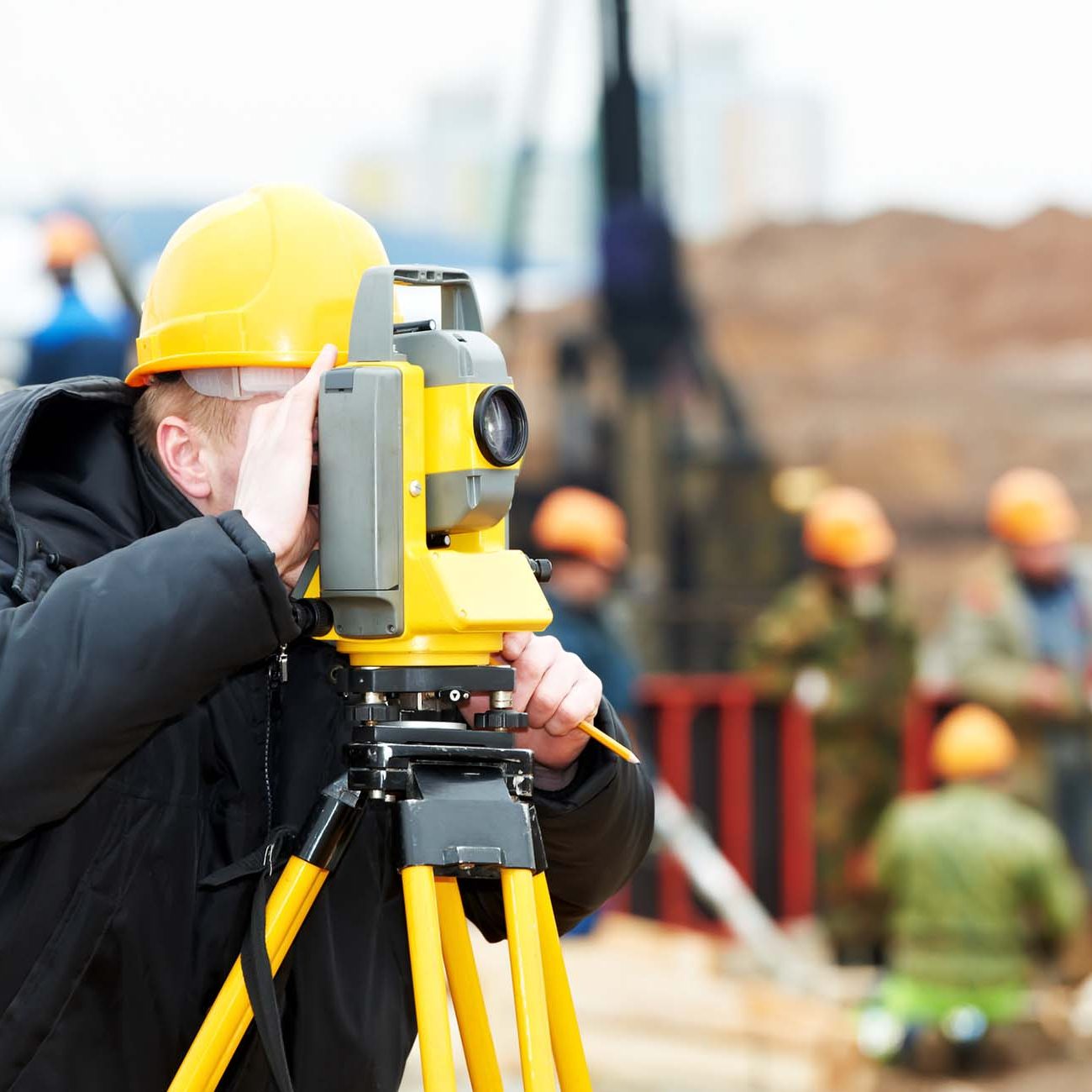 Surveyor works with theodolite. One surveyor worker working with theodolite transit equipment at construction site outdoors
